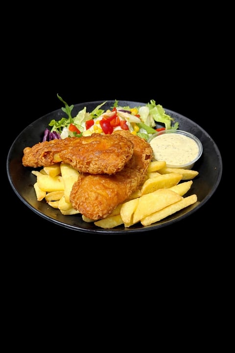 Fried fish and chips served on a black plate with fresh salad and tartar sauce on a dark background